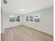 Bright living room featuring large windows that let in ample natural light and modern flooring at 7797 Barry Ct, Seminole, FL 33772