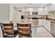 An open kitchen with granite countertops, white cabinets, stainless steel appliances and a bar at 808 3Rd W Ave # 214, Bradenton, FL 34205