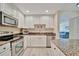 Modern kitchen features white cabinetry, granite countertops, and stainless steel appliances at 808 3Rd W Ave # 214, Bradenton, FL 34205