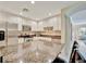 An open kitchen with granite countertops, white cabinets, stainless steel appliances and a bar overlooking the living room at 808 3Rd W Ave # 214, Bradenton, FL 34205