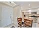 An open kitchen with granite countertops, white cabinets, stainless steel appliances and a bar next to the front door at 808 3Rd W Ave # 214, Bradenton, FL 34205