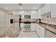 An open kitchen with granite countertops, white cabinets, stainless steel appliances and a bar at 808 3Rd W Ave # 214, Bradenton, FL 34205