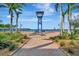 Scenic Riverwalk view with lush landscaping, blue signage, and pedestrian pathway in a waterfront community at 808 3Rd W Ave # 214, Bradenton, FL 34205