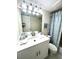 Bright bathroom with a white vanity, updated lighting, and decorative blue shower curtain at 845 Benjamin Franklin Dr # 104, Sarasota, FL 34236