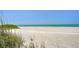 A scenic beach view with white sand meeting the tranquil, turquoise ocean under a clear blue sky at 845 Benjamin Franklin Dr # 104, Sarasota, FL 34236