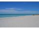Wide sandy beach with crystal clear ocean water and blue skies, offering a serene and inviting coastal experience at 845 Benjamin Franklin Dr # 104, Sarasota, FL 34236