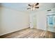 This bedroom boasts wood laminate flooring and a ceiling fan with access to an adjacent closet and hallway at 845 Benjamin Franklin Dr # 104, Sarasota, FL 34236
