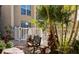 An outdoor seating area is surrounded by tropical landscaping, stone pavers and a white picket fence at 845 Benjamin Franklin Dr # 104, Sarasota, FL 34236