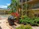 Outdoor grill area with lush landscaping, stone pavers and three-story condo building at 845 Benjamin Franklin Dr # 104, Sarasota, FL 34236