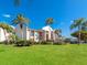 Scenic exterior view of a lovely condo featuring lush landscaping, mature palm trees and ample parking at 845 Benjamin Franklin Dr # 104, Sarasota, FL 34236