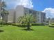 Low-rise building with beautiful landscaping and large grassy area at 845 Benjamin Franklin Dr # 104, Sarasota, FL 34236