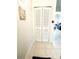 Hallway with white tiled floors, closet, and beach-themed decor; leads to a bright, inviting living space at 845 Benjamin Franklin Dr # 104, Sarasota, FL 34236