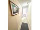 Hallway with tiled floor and beach-themed wall art leading to rooms with beautiful wood-look flooring at 845 Benjamin Franklin Dr # 104, Sarasota, FL 34236
