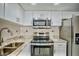Well-lit kitchen featuring stainless steel appliances, white cabinets, and a decorative backsplash at 845 Benjamin Franklin Dr # 104, Sarasota, FL 34236