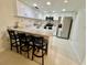 Kitchen with stainless steel appliances, granite counters, breakfast bar, and white cabinetry at 845 Benjamin Franklin Dr # 104, Sarasota, FL 34236