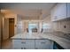 Bright kitchen with light cabinets, marbled countertops, and an adjacent dining area at 845 Benjamin Franklin Dr # 104, Sarasota, FL 34236