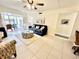 The bright living room features tile flooring and a ceiling fan, with access to the outdoor patio area at 845 Benjamin Franklin Dr # 104, Sarasota, FL 34236