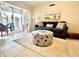 Comfortable living room with gray sofa, coastal-themed ottoman, and sliding doors to a patio at 845 Benjamin Franklin Dr # 104, Sarasota, FL 34236