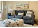 Inviting living room featuring a plush gray sofa with accent pillows and charming beach-themed artwork at 845 Benjamin Franklin Dr # 104, Sarasota, FL 34236