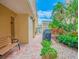 Outdoor patio area with stone pavers, lush landscaping and a bench at 845 Benjamin Franklin Dr # 104, Sarasota, FL 34236
