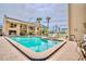 Community pool with lounge chairs, lush landscaping, and views of the condos at 845 Benjamin Franklin Dr # 104, Sarasota, FL 34236