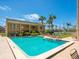 Exterior view of the sparkling in-ground pool surrounded by comfortable lounge chairs and tropical landscaping at 845 Benjamin Franklin Dr # 104, Sarasota, FL 34236
