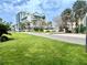 Street view featuring palm trees, grassy areas, and nearby building at 845 Benjamin Franklin Dr # 104, Sarasota, FL 34236