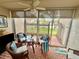 Cozy sunroom with brick flooring, wicker furniture, and views of the well-manicured yard at 845 Benjamin Franklin Dr # 104, Sarasota, FL 34236