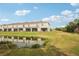 Townhome backyard offering a serene view of a pond, greenery, and a glimpse of neighborhood amenities at 8600 Milestone Dr, Sarasota, FL 34238