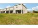 Exterior rear view of a modern townhome with well-kept lawn and enclosed patio at 8600 Milestone Dr, Sarasota, FL 34238