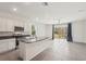 Bright kitchen features stainless appliances, granite countertops, island, and tile flooring at 8600 Milestone Dr, Sarasota, FL 34238