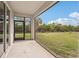 Screened lanai with concrete flooring and a view of the green backyard at 8600 Milestone Dr, Sarasota, FL 34238
