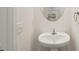 Clean white powder room with a sleek white pedestal sink and mirror at 8600 Milestone Dr, Sarasota, FL 34238