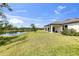 Backyard view featuring a covered patio, lake and green grass at 9215 Royal River Cir, Parrish, FL 34219