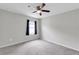 Bedroom with ceiling fan, neutral walls, and a window with dark curtains at 9215 Royal River Cir, Parrish, FL 34219