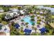 Aerial view of a luxurious community pool area with cabanas and palm trees, great for relaxing at 9215 Royal River Cir, Parrish, FL 34219