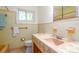 Vintage bathroom with unique pink and yellow tile, a coordinating sink, and a stained glass window at 923 Dawn St, Venice, FL 34285