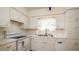 Clean, all white kitchen with a double basin sink, dishwasher and tile backsplash, ready for cooking at 923 Dawn St, Venice, FL 34285