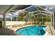 Enjoy this beautiful screened-in pool with brick pavers and a lush backyard view for outdoor living and entertaining at 923 Dawn St, Venice, FL 34285