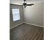 Bedroom featuring neutral walls, wood floors, ceiling fan and a large window offering tons of natural light at 10668 Lake Montauk Dr, Riverview, FL 33578