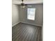 Bedroom showcasing wood-look flooring, neutral paint, modern ceiling fan, and lots of natural light at 10668 Lake Montauk Dr, Riverview, FL 33578