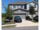 Charming two-story home featuring a gray exterior, well-maintained landscaping, and an attached two-car garage at 10668 Lake Montauk Dr, Riverview, FL 33578