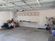 Spacious two-car garage equipped with overhead shelving, wall hooks, and workbench providing ample storage space at 10668 Lake Montauk Dr, Riverview, FL 33578