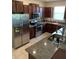 Kitchen displaying stainless steel appliances, granite counters, and dark wood cabinets offering plenty of storage at 10668 Lake Montauk Dr, Riverview, FL 33578