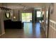 Open-concept living room with tile floors, ceiling fan, and sliding glass doors leading to a tranquil outdoor view at 10668 Lake Montauk Dr, Riverview, FL 33578