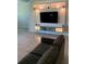 Relaxing living room with large flat-screen TV, custom wall shelving, and cozy couch seating at 10668 Lake Montauk Dr, Riverview, FL 33578