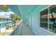 Exterior hallway of complex with calming blue walls and palm trees, with views of the water at 117 7Th N St # 14, Bradenton Beach, FL 34217