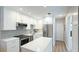Updated kitchen features stainless steel appliances, white cabinets, tile backsplash, and large island at 117 7Th N St # 14, Bradenton Beach, FL 34217