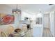 Bright kitchen with white cabinets, stainless steel appliances, and adjacent dining area with stylish light fixture at 117 7Th N St # 14, Bradenton Beach, FL 34217