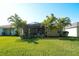 The backyard is a tropical oasis with lush grass, mature trees, and a screened-in lanai at 11836 Crawford Parrish Ln, Parrish, FL 34219